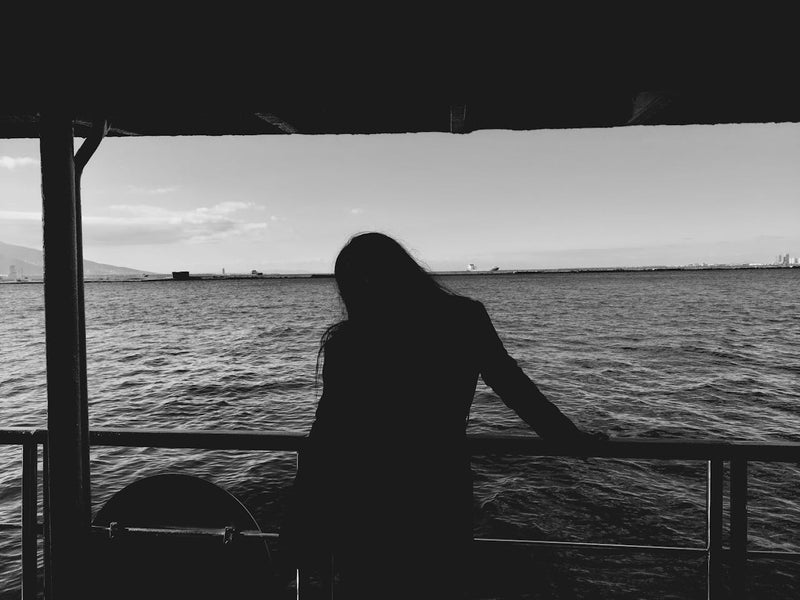 Silueta de mujer mirando hacia el mar